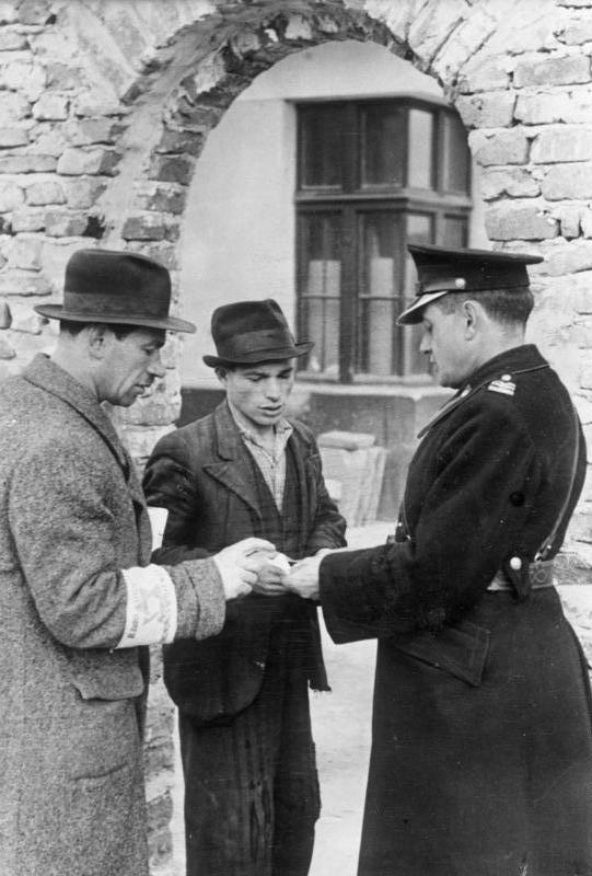 Granatowy policjant kontroluje dokumenty w getcie, 1941. Źródło: Bundesarchiv/Wikimedia Commons. Holocaust w Krakowie